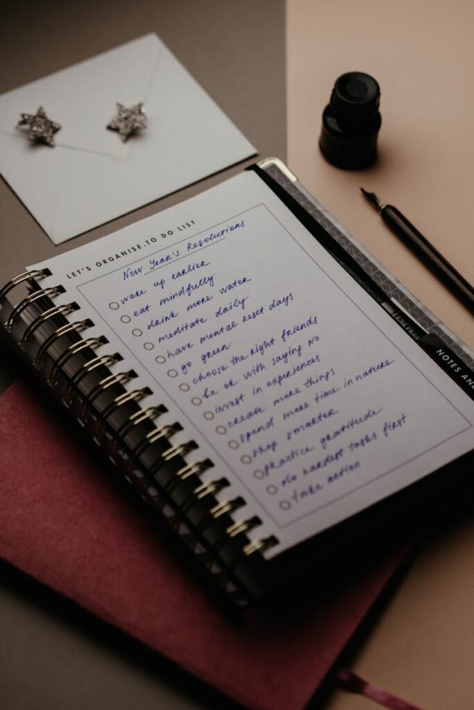 pexels-photo-5717425-5717425 Spiral notebook with New Year's resolutions in a cozy still life setting, perfect for planning.