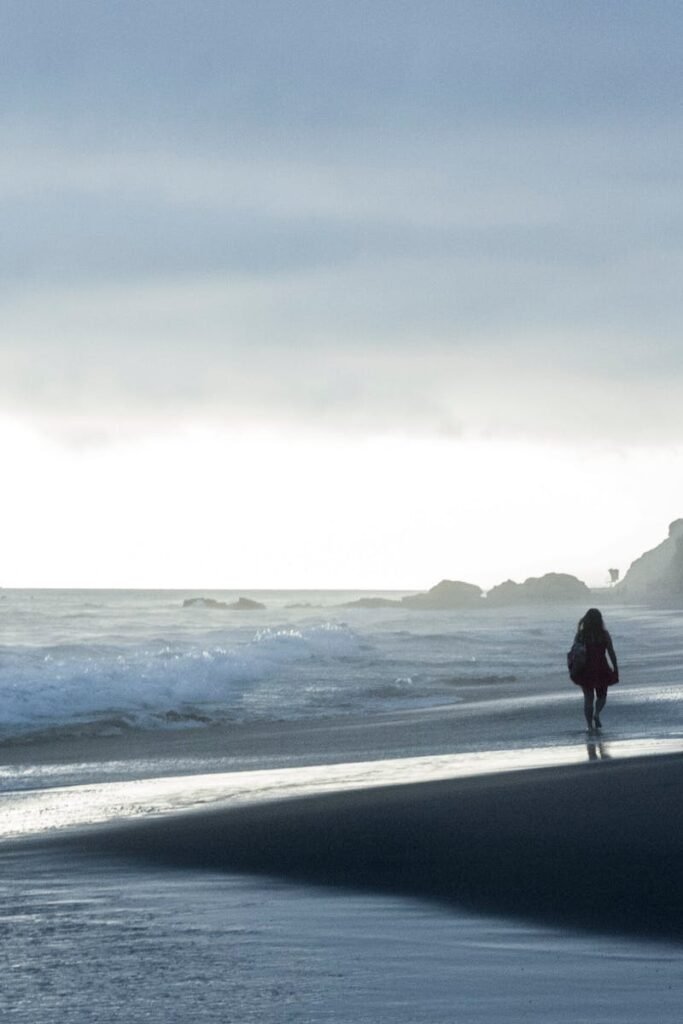 pexels-photo-3782438-3782438 A woman walks along the calm Laguna Beach shoreline during a dramatic evening. Captivating clouds and waves.