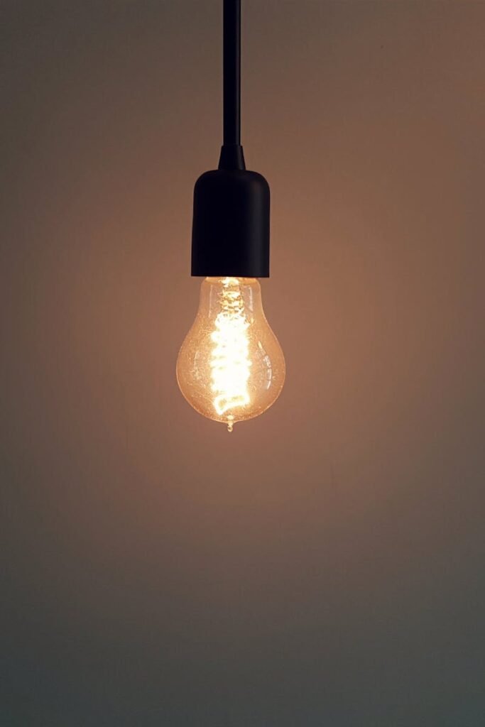 pexels-photo-132340-132340 Simple illuminated light bulb hanging in a dark room, creating a warm atmosphere.